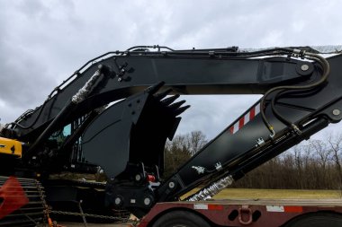 On highway, heavy construction equipment is being carried a trailer platform