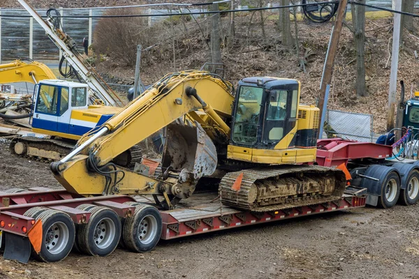 Using trailer platform to carry heavy construction equipment is a dangerous task
