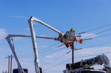 A technician in electrical power pole maintenance industry has been hired to repair the after storm damaged power lines.