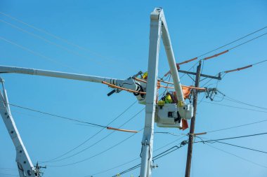 It is job for the electrician worker to repair the damaged power lines caused by storm in electric power pole maintenance industry