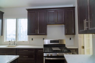 Installed kitchen wooden cabinets with a view of home improvement in a set of furniture being constructed