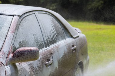 During cleaning washing in a car wash with using soap water on power water jet spraying