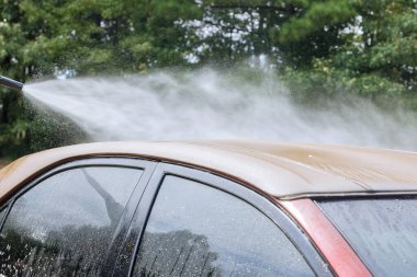 A man washing car under high pressure jet spraying water with cleaning car