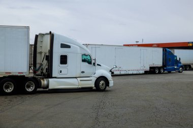 Resting place the truck stop various types of trucks in parking lot the highway with gas station for refueling car in the US. clipart