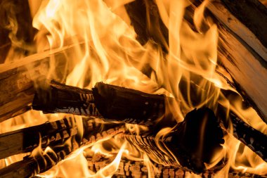 There is a fire blazing in the wood-fired traditional pizza oven with flames erupting from behind it