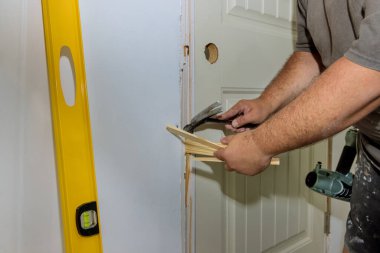 Çekiç, yeni evin iç kapılarını döşeyen işçilerden biri tarafından kullanılıyor.