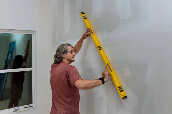 Empregado Verifica Nível Uma Parede Drywall Antes Pintar Usando Nível — Fotografia de Stock