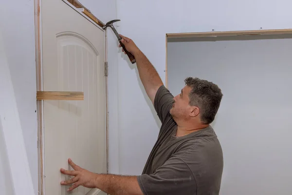Trim Worker Utiliza Martillo Instalar Puertas Interiores Una Casa Nueva — Foto de Stock