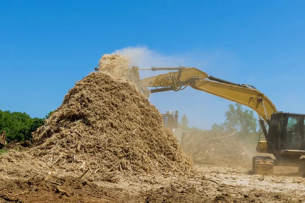 Land that is being prepared for building housing development with industrial shredder machine work the roots shredding to chips in construction site