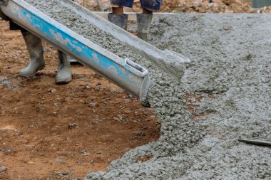 Otopark için beton yollar inşaat alanında çalışan bir işçi tarafından dökülüyor.