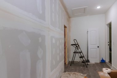 Finishing plastering drywall is ready for paint with newly constructed house construction clipart