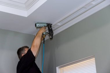 Yeni evin inşaatı sırasında, profesyonel tamirci pencerenin üzerindeki duvarı çivilemek için tahta kornişler yaptı..