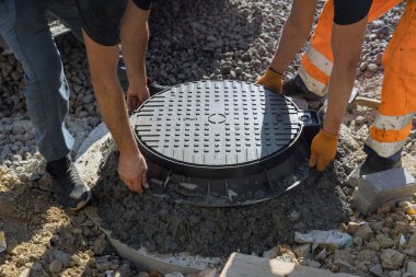 Beton kuyuya döşenmiş dökme demir kanalizasyon. Su kanalizasyonu kuyusu inşasına hazırlık.