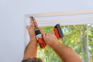 Pencerelere panjur montajı sırasında yeni inşa edilen evler, profesyonel bir teknisyen tarafından vidalanır