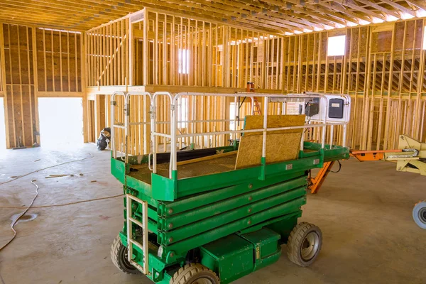 An employee construction company uses boom truck forklift to move framing beams for on construction site.
