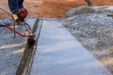 Yeni garaj yolu inşaatı, taze beton sıkıştırılmış katman seviyesini hizalamak için kullanım makinesini içeriyor