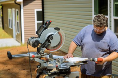 İnşaat işleri için ahşap tahtaları bağlamak için marangoz tornavida kullanıyor..