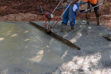 Yeni garaj yolu inşaatına taze beton sıkıştırılmış katmanı hizalamak için makine.