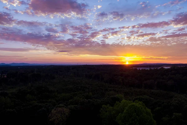 美しい紫色の夕日の間にカラフルな空は明るいオレンジ色の光で照らされています — ストック写真