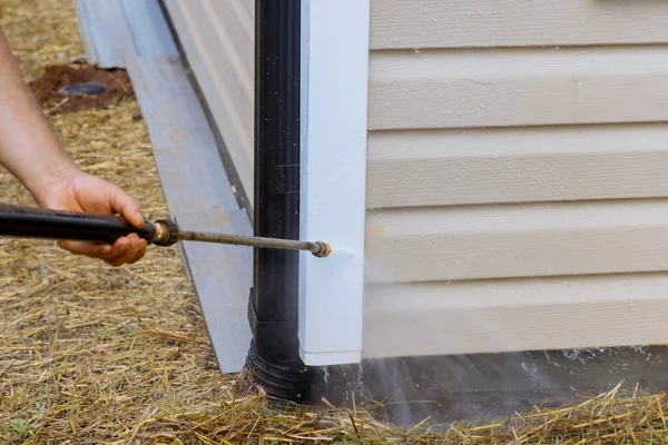 Maintenance services for washing siding house by using high pressure nozzles that spray water soap cleaner to clean home