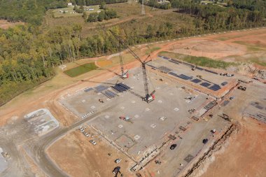 Yüksek binaların inşaat sahasında çalışan vinçlerin havadan görüntüsü
