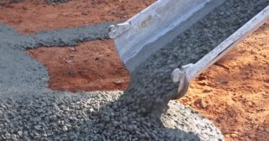 Beton, yeni evin yakınındaki inşaat alanının kaldırımlarına dökülüyor..