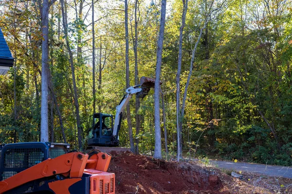 Clear land for construction of new housing development, tractor skid steers were used to uproot trees
