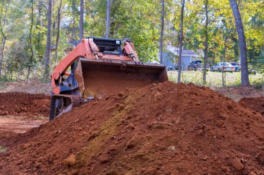 İnşaat alanlarında, peyzaj için toprak taşımak için küçük traktörler kullanılır.