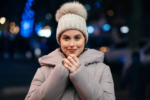夜の街路灯の外の女性冬の寒い天候は口から蒸気で彼女の手を暖める クリスマスツリー新年の雰囲気の照明コピースペース — ストック写真