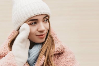 Örgü şapka eldivenleri giymiş, kameraya bakan genç ve güzel bir kadın. Soğuk hava, kış tatili, seyahat. Yeni yıl Noel süsleri, Sevgililer Günü konsepti fotokopi alanı