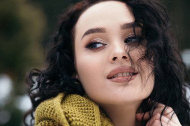 Güzel kadın gülümsüyor sokak karları eski orman hava durumu kış tatili yeni yıl Noel 'i örgü, kalın kazak ve eşarp, mavi gözler fotokopi alanı bulanık arka plan.