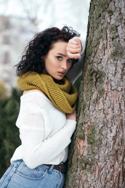 Güzel kadın gülümsüyor sokak karları eski orman hava durumu kış tatili yeni yıl Noel 'i örgü, kalın kazak ve eşarp, mavi gözler fotokopi alanı bulanık arka plan.