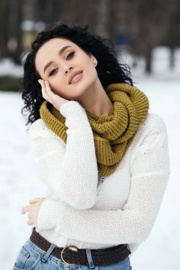 Güzel kadın gülümsüyor sokak karları eski orman hava durumu kış tatili yeni yıl Noel 'i örgü, kalın kazak ve eşarp, mavi gözler fotokopi alanı bulanık arka plan.