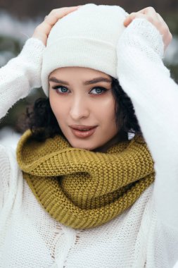 Güzel kadın gülümsüyor sokak karları eski orman hava durumu kış tatili yeni yıl Noel 'i örgü, kalın kazak ve eşarp, mavi gözler fotokopi alanı bulanık arka plan.