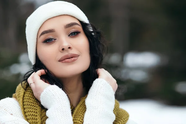 美丽的女人笑着站在街道外雪原公园森林天气寒假圣诞服装针织暖毛衣围巾蓝眼睛复制空间模糊背景 — 图库照片