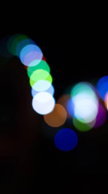 Kafe restoranının yakınındaki Bokeh arka plan efekti sokağında parıldayan soyut bir akşam. Şehir yaşamının odağından çıkarılmış altın renkli çelenkleri bulanıklaştırıyor. Yılbaşı partisi konsepti. 