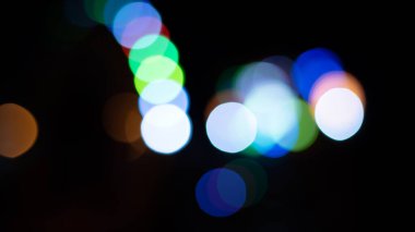 Kafe restoranının yakınındaki Bokeh arka plan efekti sokağında parıldayan soyut bir akşam. Şehir yaşamının odağından çıkarılmış altın renkli çelenkleri bulanıklaştırıyor. Yılbaşı partisi konsepti. 