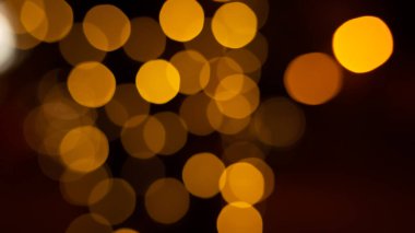 Kafe restoranının yakınındaki Bokeh arka plan efekti sokağında parıldayan soyut bir akşam. Şehir yaşamının odağından çıkarılmış altın renkli çelenkleri bulanıklaştırıyor. Yılbaşı partisi konsepti. 