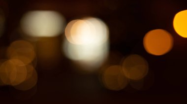 Kafe restoranının yakınındaki Bokeh arka plan efekti sokağında parıldayan soyut bir akşam. Şehir yaşamının odağından çıkarılmış altın renkli çelenkleri bulanıklaştırıyor. Yılbaşı partisi konsepti. 
