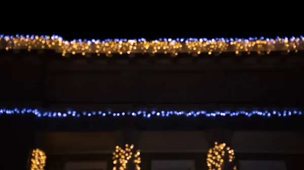 摘要傍晚时分 夜光闪烁着的背景效果街道附近的咖啡馆餐厅 城市生活的脱色模糊了金色灯泡的花环 圣诞新年派对假期的概念 — 图库照片
