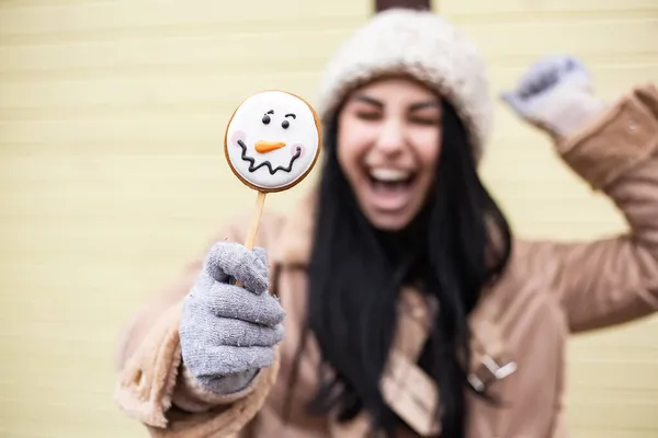 若いかなり笑顔を開いて口の白い歯の女性を祝うホールドはロリポップ甘いキャンディー雪だるまを食べる 寒い天候 冬の市場の休日の公正 旅行リゾート 新年クリスマスツリーの装飾 — ストック写真