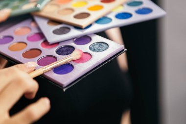 Premium kapat profesyonel çok renkli yapım yüz kozmetik koleksiyonu aksesuar palet seti masa güzelliği dokusu üzerine renkli parlak göz farı stüdyo düz yatıyordu