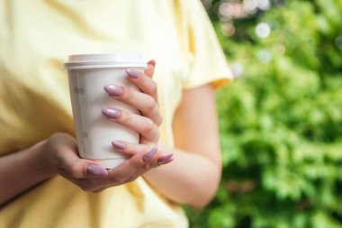 1 Ekim, Uluslararası Kahve Günü! Yeşil ağaçların dışındaki park kapalı. Plastik beyaz bardak sıcak içecek. Kahve molası.