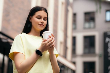 1 Ekim, Uluslararası Kahve Günü! Kafe restoranının ya da otelin önünde duran bir kadın plastik bardak sıcak içecek kahve molası verir, işten sonra dinlenir, yaz günleri fotokopi çeker.