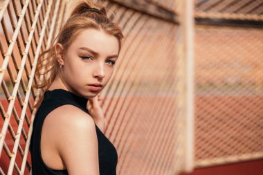 Woman standing relaxing outside after cardio training outside stadium in the morning. Athletic lady dressed fitness sportwear. Healthy lifestyle, sport and recreation concept.