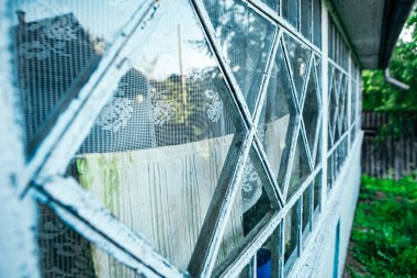 Close up view of abandoned painted white glass terrace, exterior of old house in village. Yard in small town. Empty free copy space for text or message. 