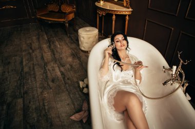 Stüdyodaki fotoğraf çekiminde eşi. Evli gelin nişanı kutluyor. Üreme romantik inanılmaz kadın kapalı, kopyalama alanı. Düğün gününe hazırlanıyorum, banyoda yatıyorum ve musluğu tutuyorum.