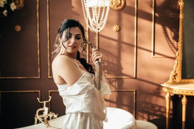 Stüdyodaki fotoğraf çekiminde eşi. Evli gelin nişanı kutluyor. Üreme romantik inanılmaz kadın kapalı, kopyalama alanı. Düğün gününe hazırlanmak, banyonun yanında durmak ve musluğu tutmak.