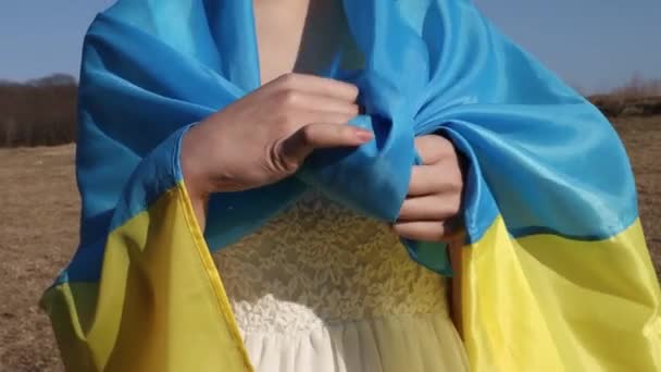 女性は ウクライナの黄色の青い旗のフラッタは 風のネクタイ結び目を振って包まれた ウクライナの象徴 メイクをした愛国的な女性 ウクライナとのスタンド サポートと連帯 — ストック動画