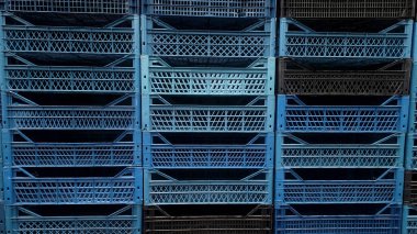 Renkli plastik sandıklar. Mal ürünleri için boş kutular. Çiftçi marketinin deposunda sebzeler. Katlanabilir ve istiflenebilir depolama